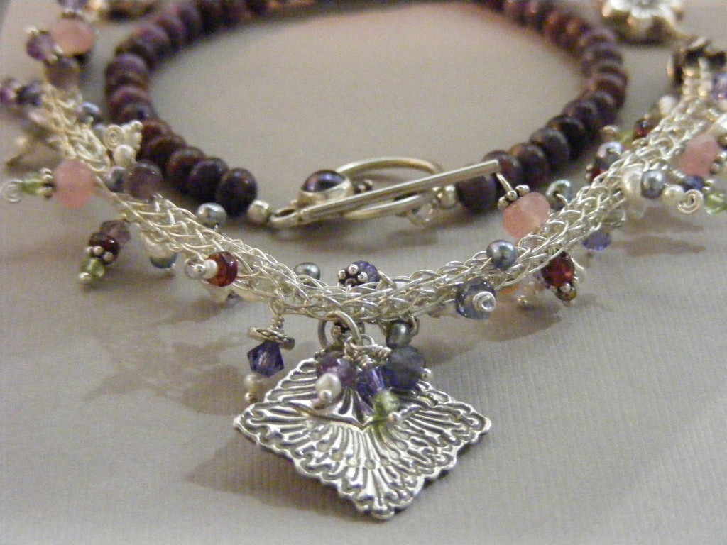 Woven wire viking knit necklace embellished with keshi pearls, Swarovski crystals, gemstone beads, and silver dangles, strung on a Plum pearl accent in the box clasp.